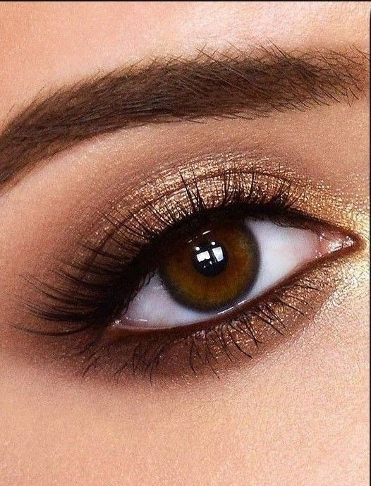 a woman's eye with brown and gold makeup