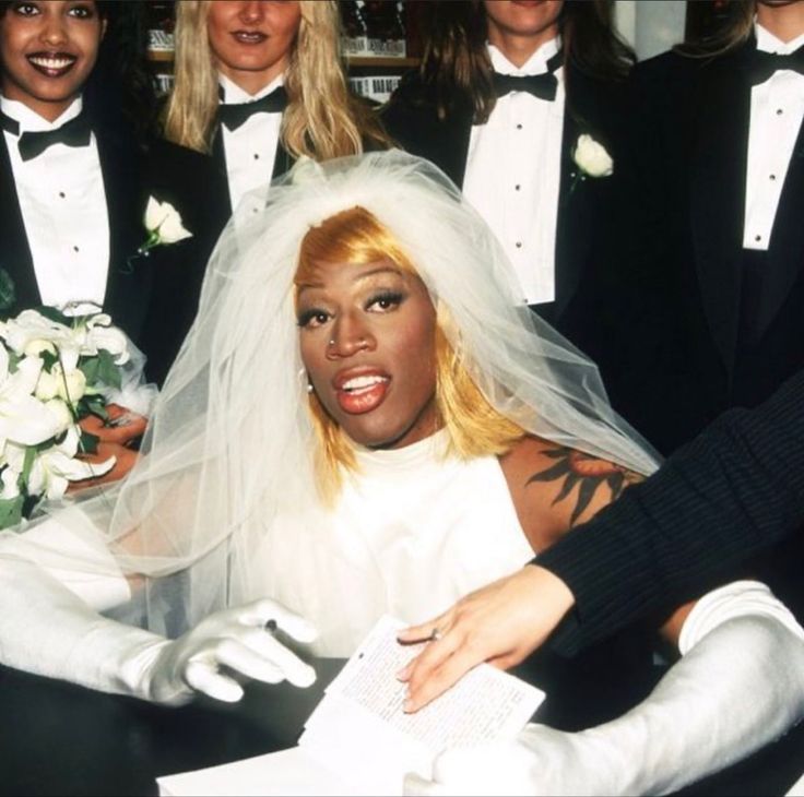 a group of women dressed in black and white posing for a photo on their wedding day