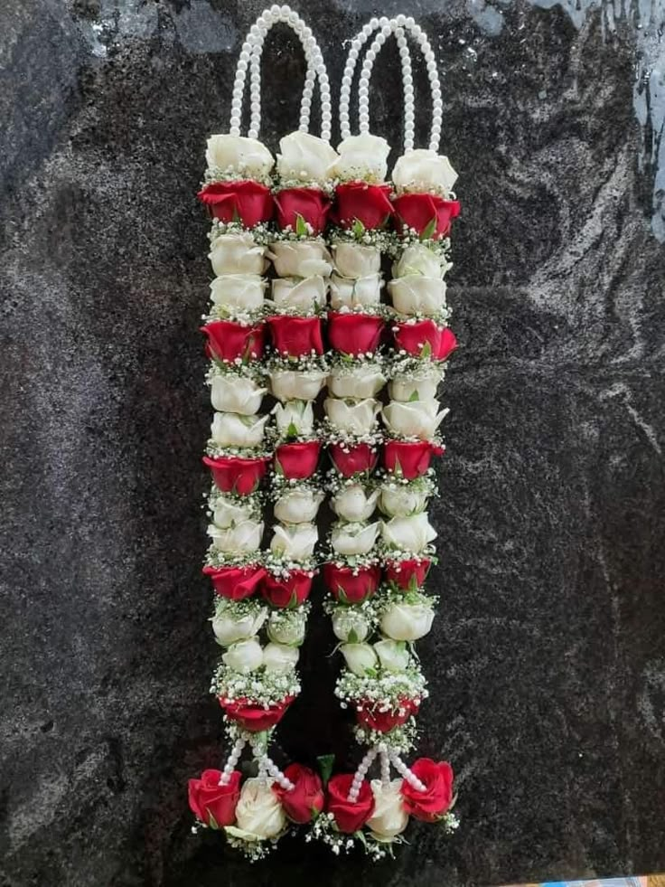 flowers arranged in the shape of letters on a stone wall with red and white roses