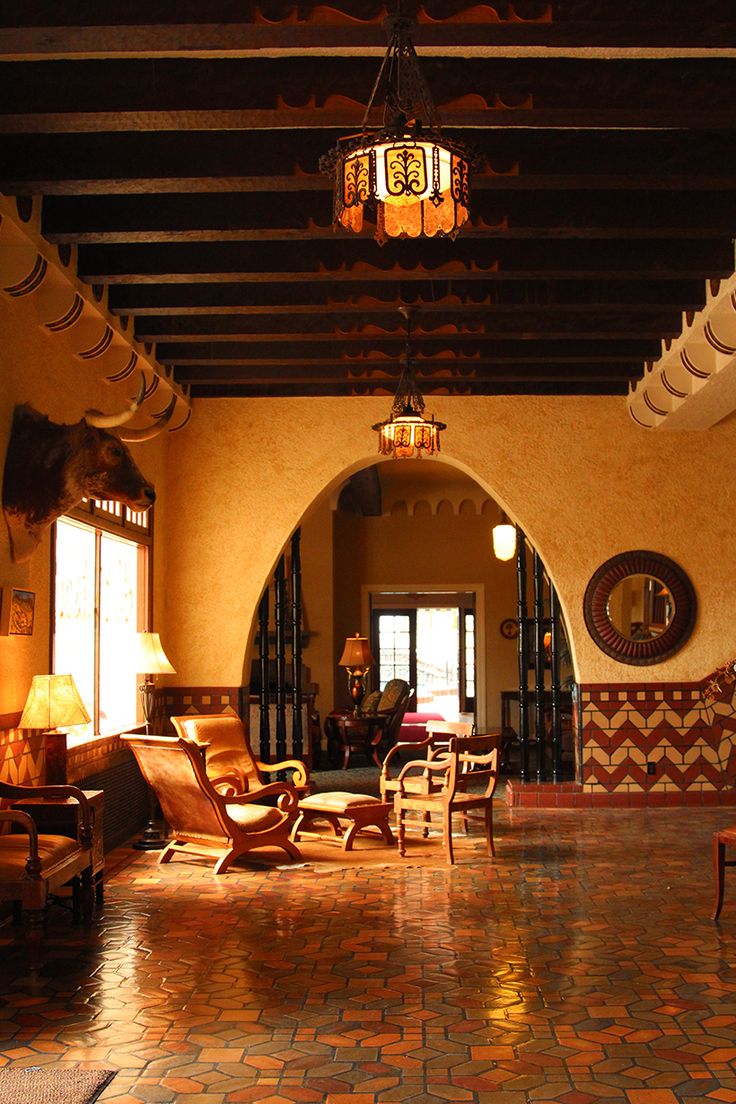 a living room filled with lots of furniture and decor on top of tiled flooring