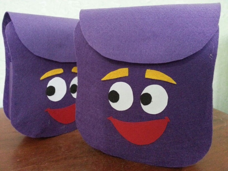 two purple bags with faces on them sitting on a table