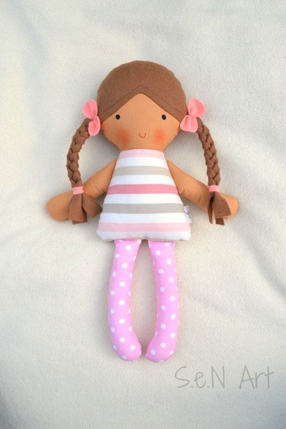 a doll with braids laying on a white sheet in the shape of a ballerina