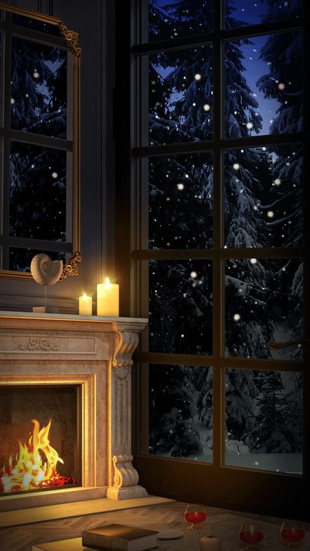 a room with a fire place and a window that has snow falling on the trees outside