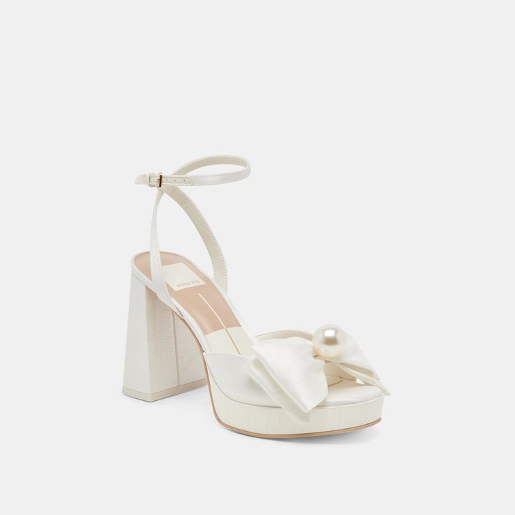 a white high heeled sandal with a bow