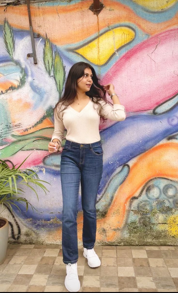 a woman standing in front of a colorful wall