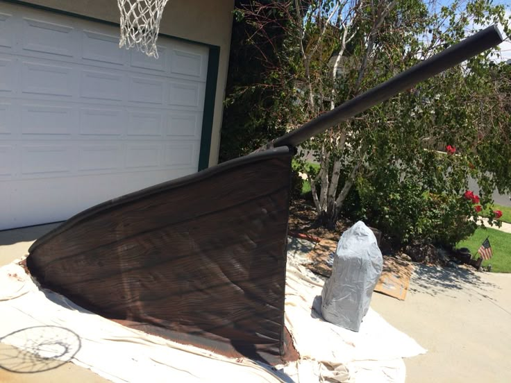 an upside down umbrella sitting in front of a garage door next to a fire hydrant