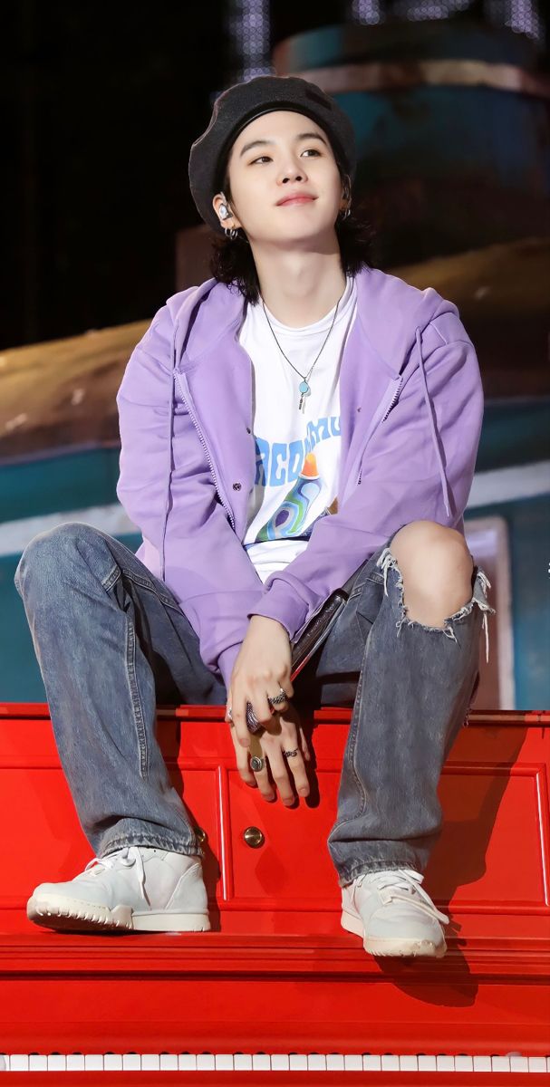 a young man sitting on top of a red bench