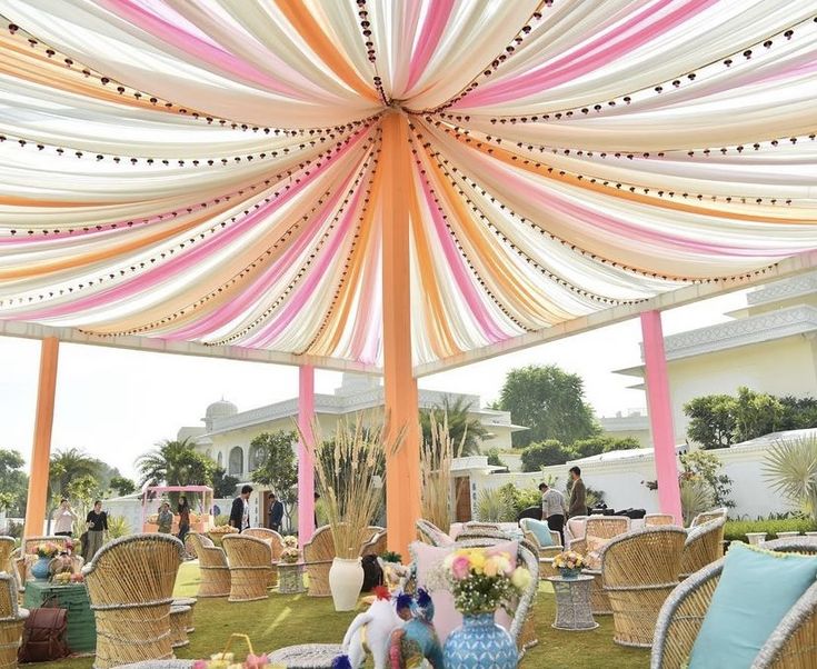 an outdoor event with tables and chairs covered in colorful fabric