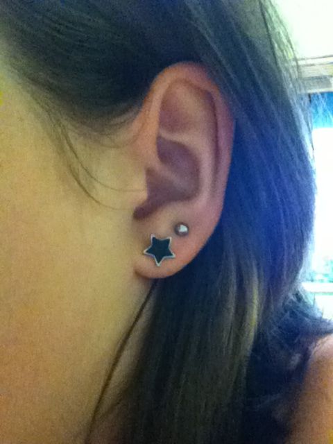 a woman wearing an ear piercing with stars on it