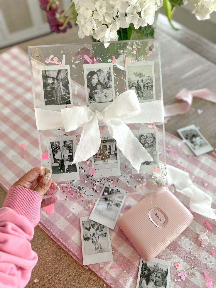 a table topped with pictures and pink flowers