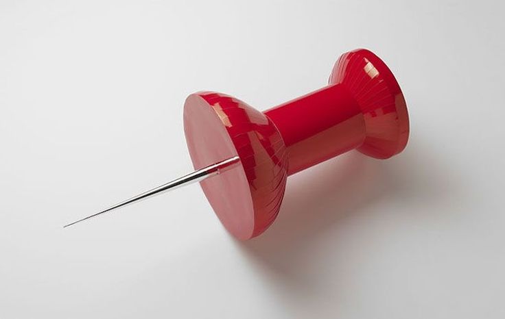 a red button with a needle sticking out of it