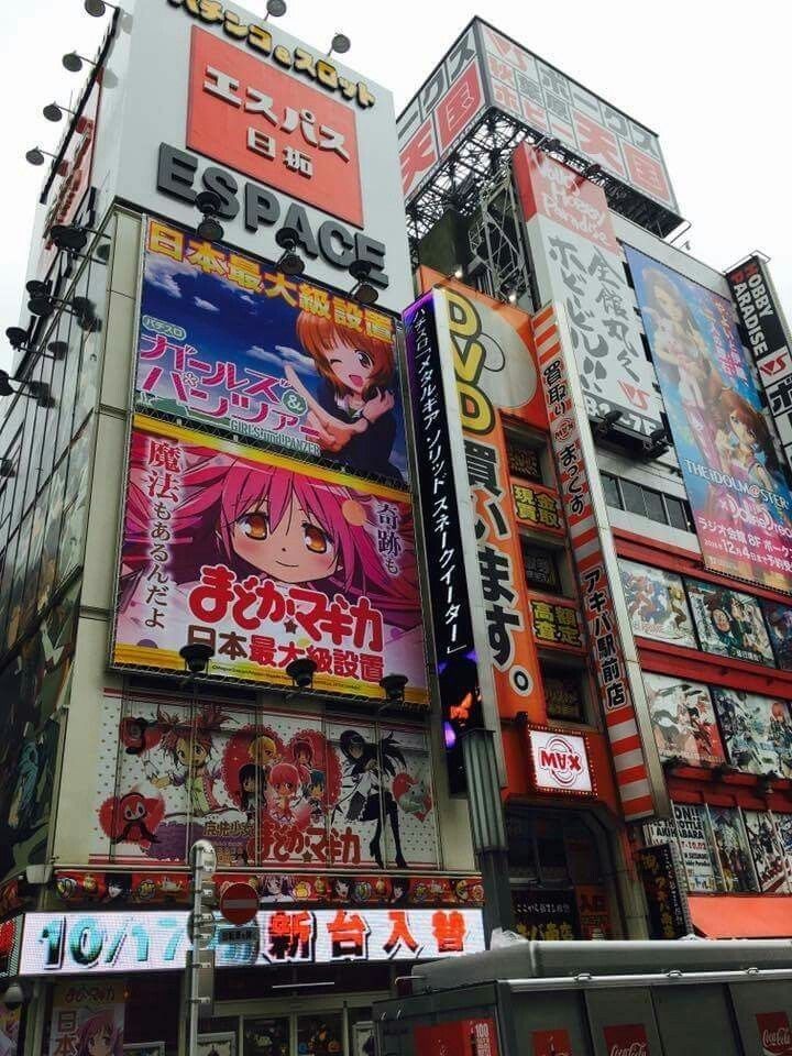 a large building with many advertisements on it's side in tokyo, japan during the day