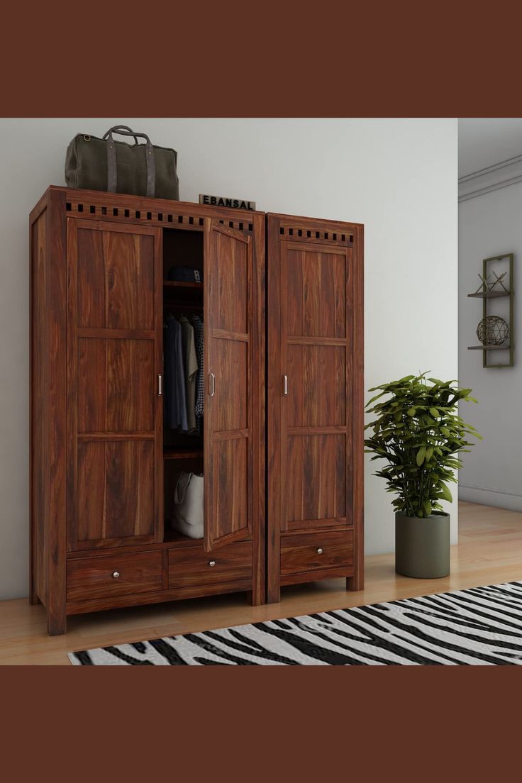 a large wooden cabinet sitting on top of a hard wood floor next to a potted plant