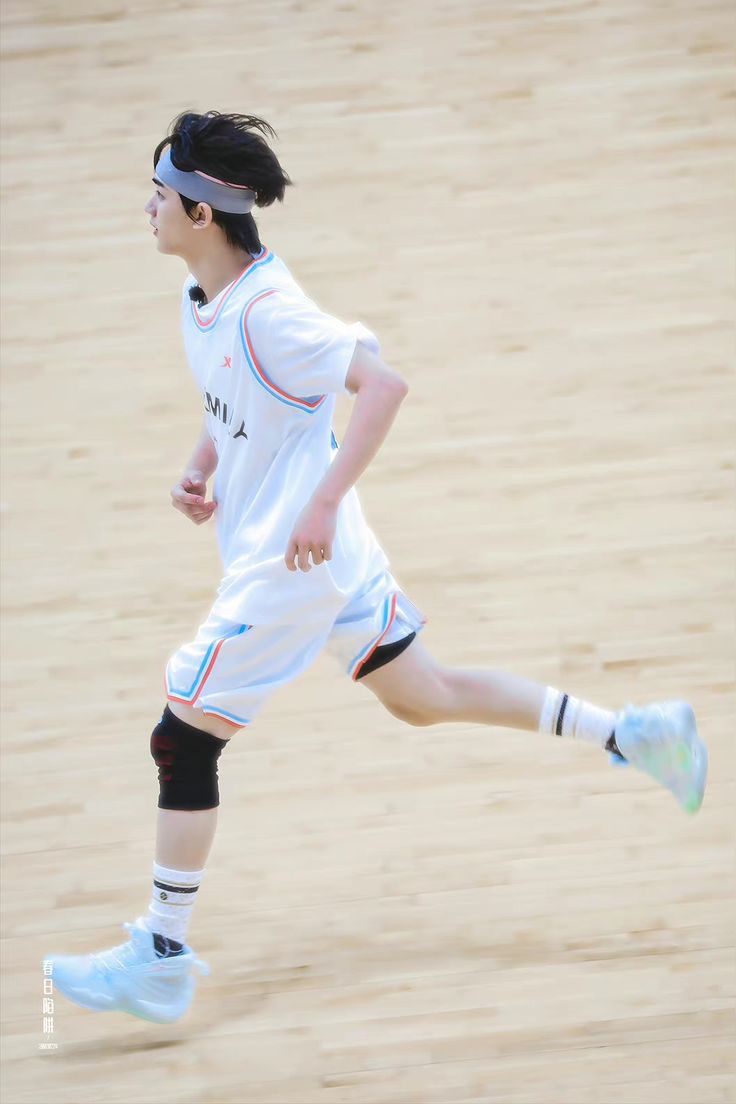 a young man running across a sandy beach