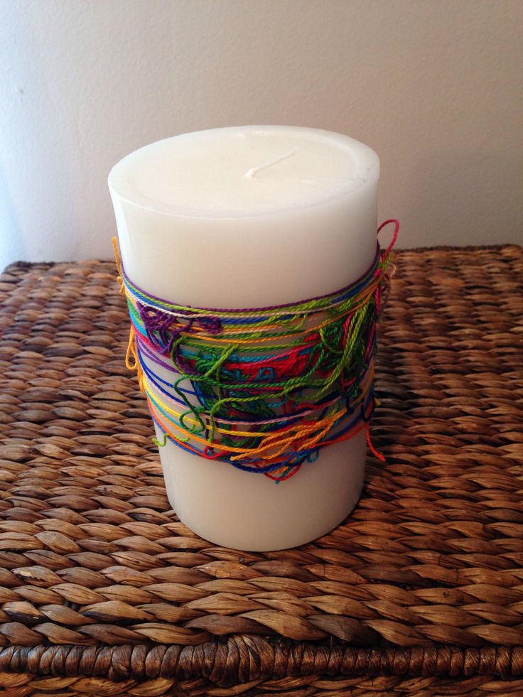 a white candle sitting on top of a wicker table