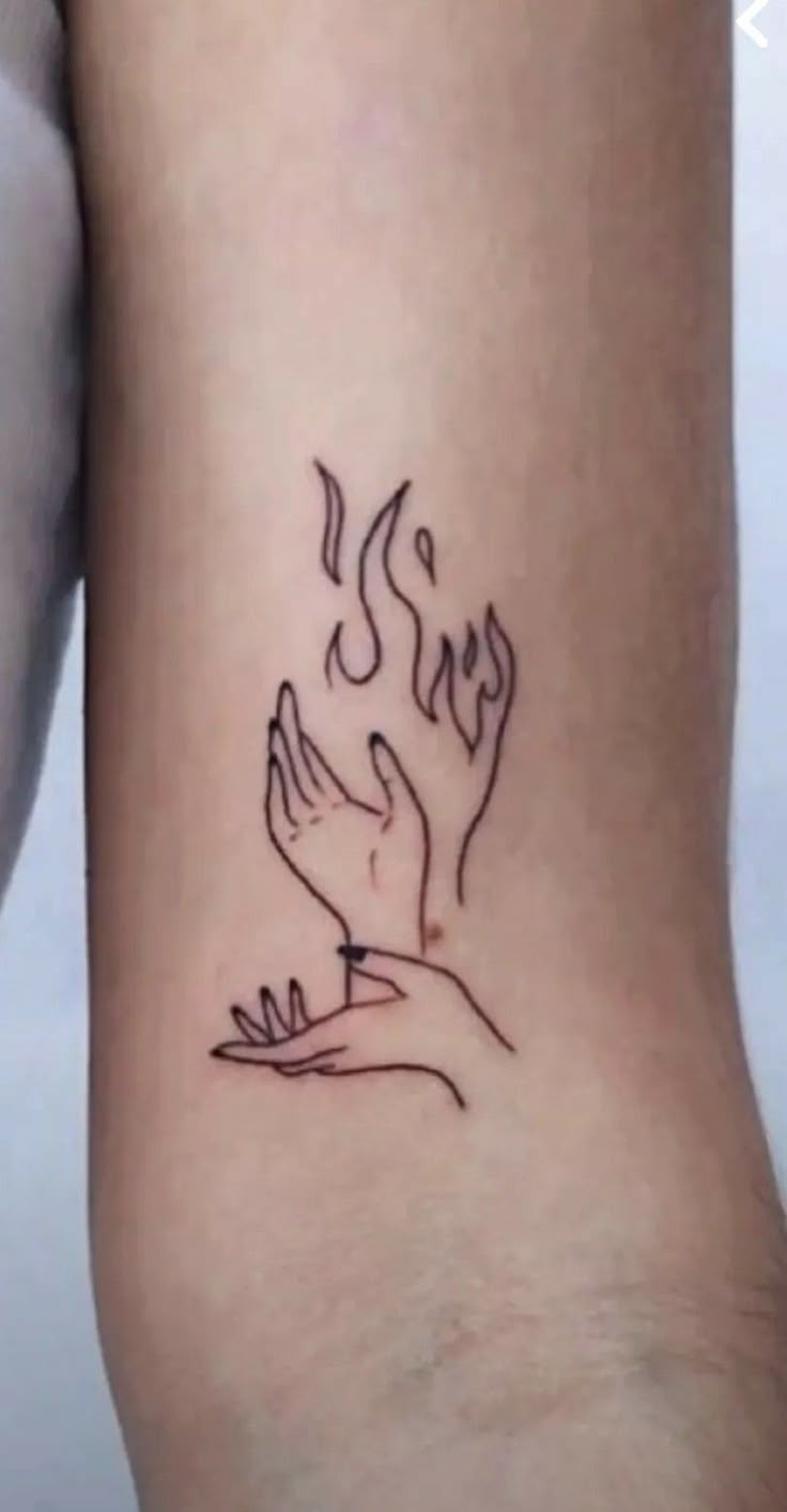 a woman's foot with a tattoo on it that has two hands holding something