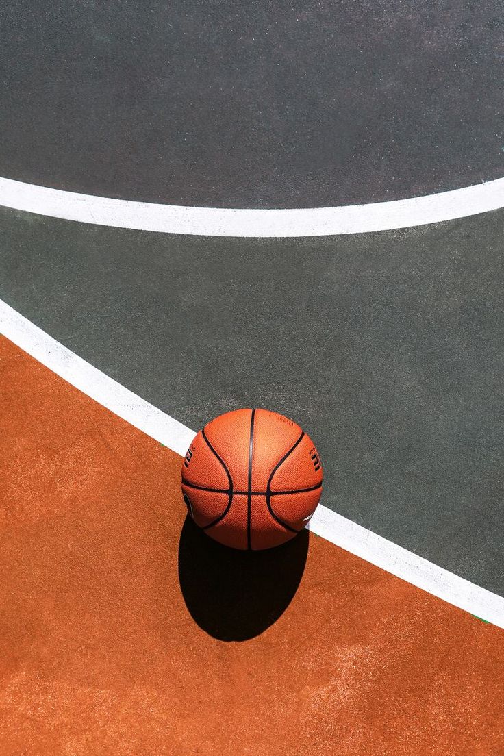 a basketball sitting on top of an orange court