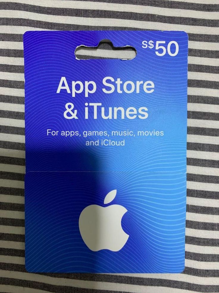 an apple store and itunes gift card sitting on top of a striped bed sheet in front of a black and white wall