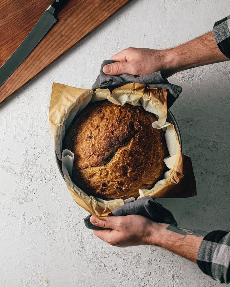 a person holding a loaf of bread in their hands