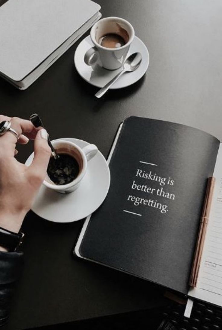 a person sitting at a table with a book and cup of coffee in front of them