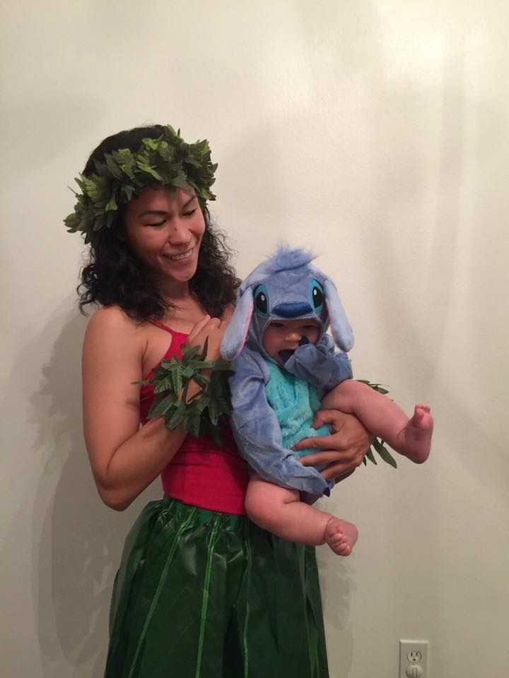 a woman is holding a baby dressed as peter the rabbit and wearing a wreath on her head