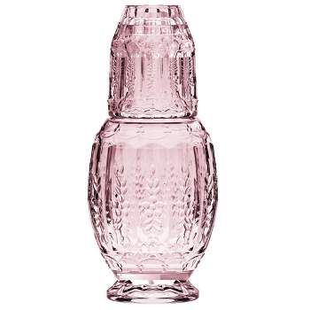 an empty pink glass bottle on a white background