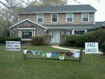 two lawn signs are in front of a house with bunting flags on the grass