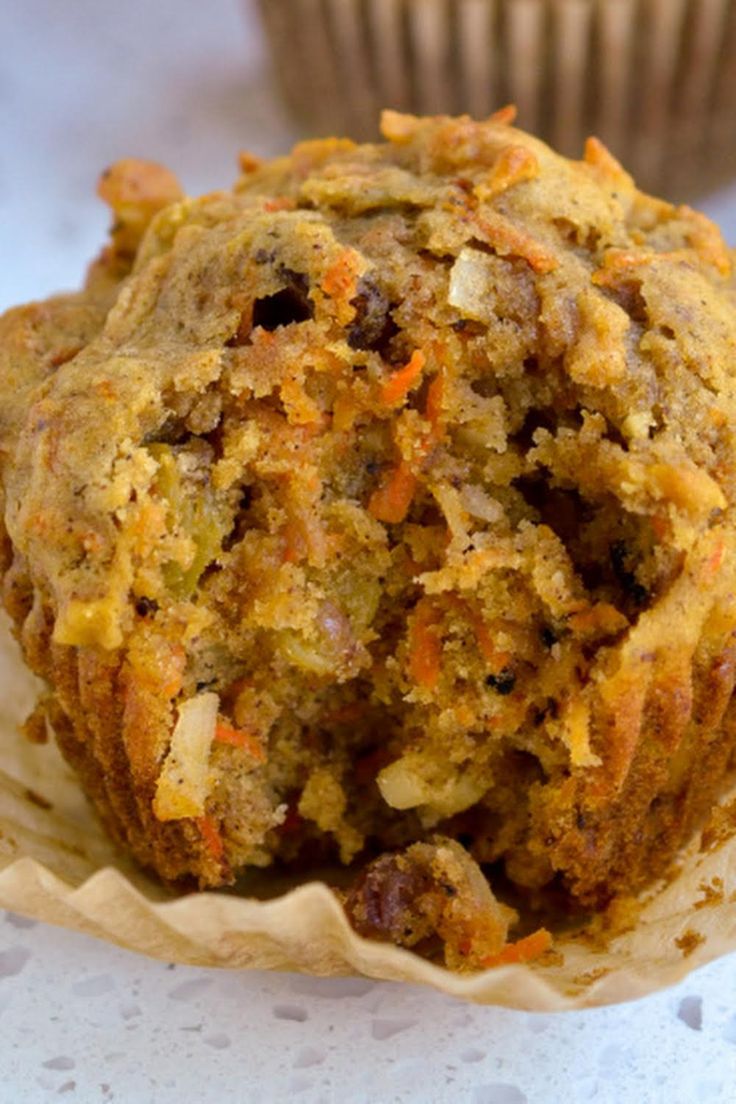 a muffin sitting on top of a table next to a cupcake