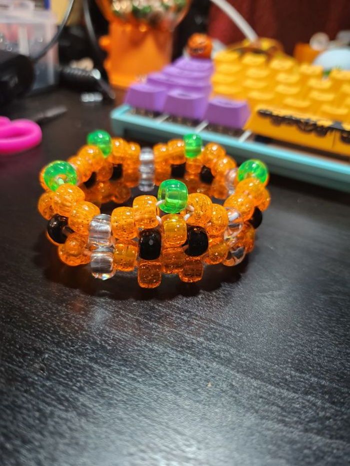 two bracelets made out of plastic beads sitting on a table next to a keyboard