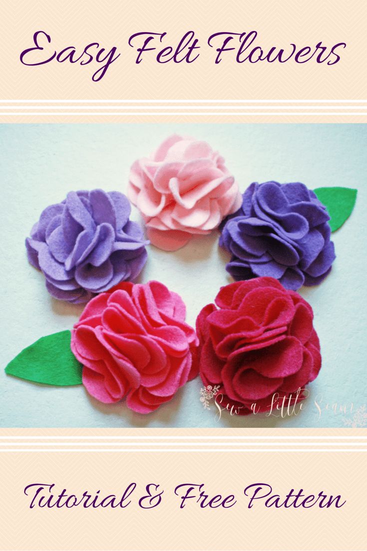 four felt flowers with green leaves and pink, purple, and red flowers on them