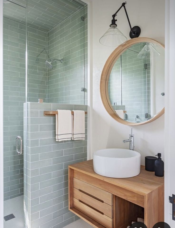 a bathroom with a sink, mirror and shower stall