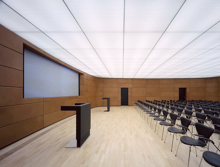 an empty lecture hall with chairs and a podium