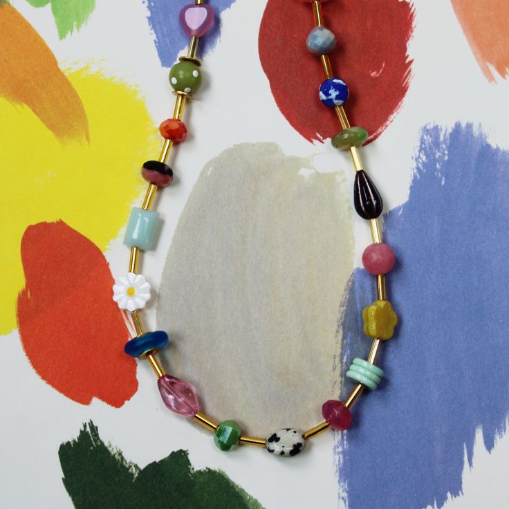 The Mariposa Beaded Necklace is fun personified. This multicolored, beaded necklace is sure to make you smile. This necklace is handmade using an assortment of beads including Czech glass and gemstone beads on a single strand of colorful loveliness! While each bead might have a different color, consistency, pattern, texture and shape, they are all separated by a cylindrical golden bead. This allows for you to really be able to see the unique beauty of the necklace and still have unity in the des Fun Beaded Necklaces With Tiny Beads For Gifts, Fun Beaded Necklace With Tiny Beads For Gift, Whimsical Adjustable Beaded Necklace With Colorful Beads, Multicolor Czech Glass Necklaces With Oval Beads, Multicolor Czech Glass Necklace With Oval Beads, Multicolor Czech Glass Oval Bead Necklace, Whimsical Adjustable Beaded Necklaces With Heart Beads, Fun Beaded Necklaces As Gift, Multicolor Czech Glass Gemstone Beads