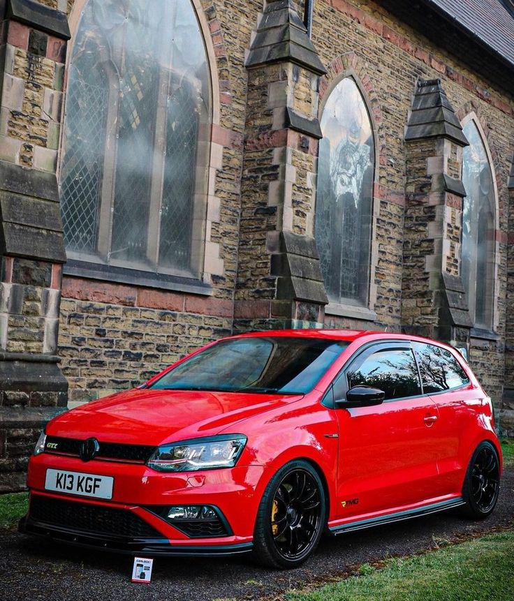 a red car parked in front of a brick building