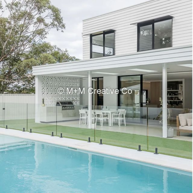 a house with a pool in front of it and an outdoor dining area on the other side