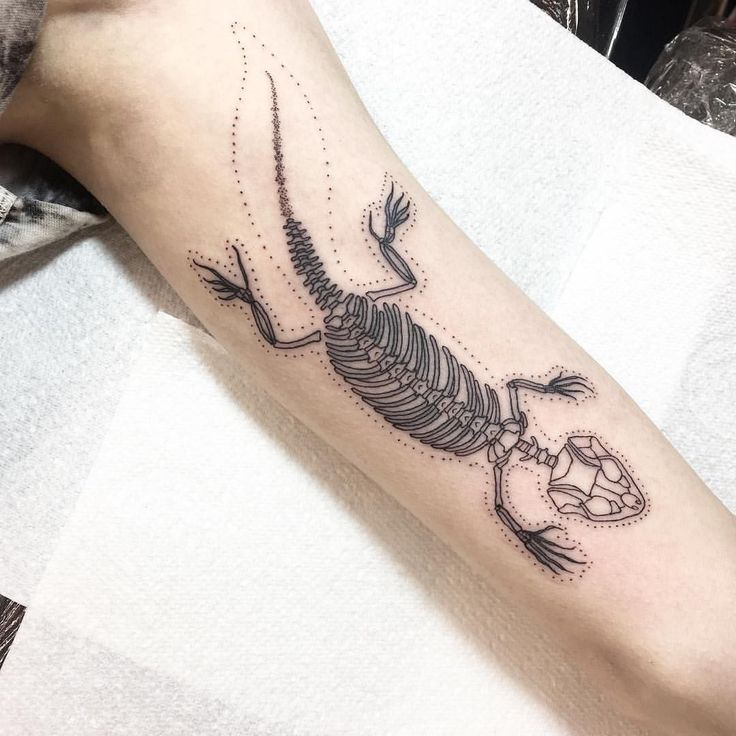 a tattoo on the arm of a person with a skeleton and diamond in it's claws