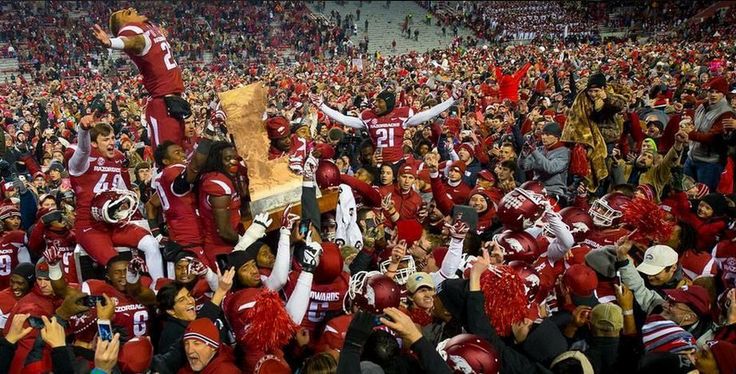 a large group of people in red and white uniforms at a football game with fans