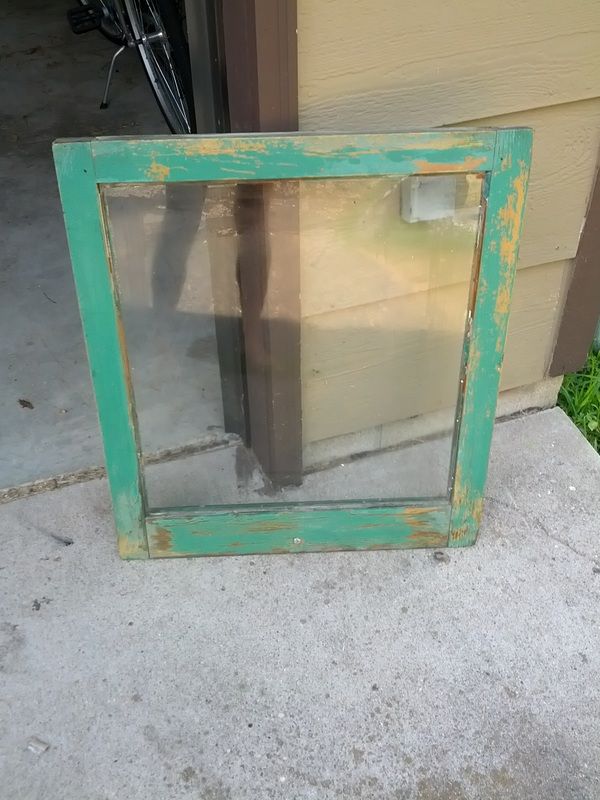 an old window sitting on the side of a house