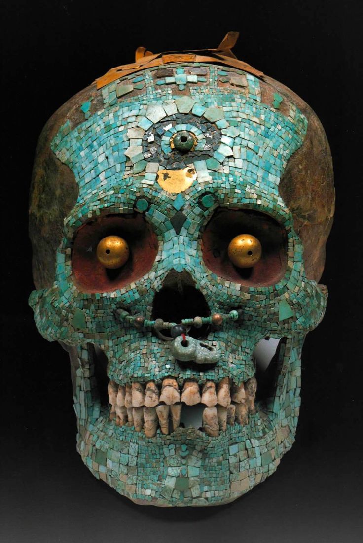 a blue and green skull with gold eyes