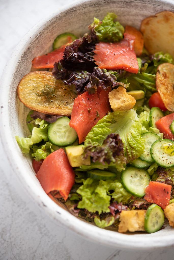 a white bowl filled with lots of different types of food on top of a table