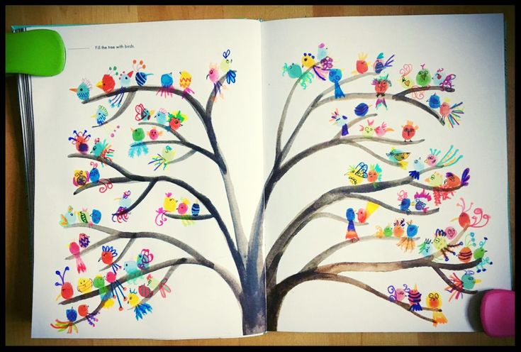 an open children's book with colorful handprints on the pages and tree