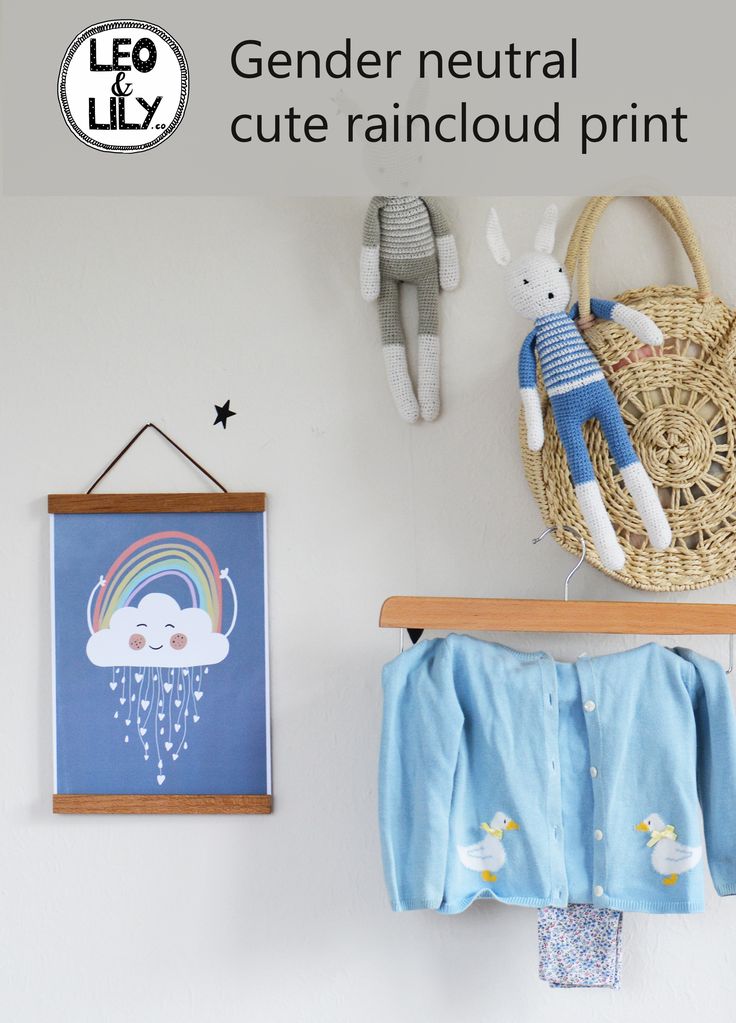 a baby's room with toys hanging on the wall and an art piece above it