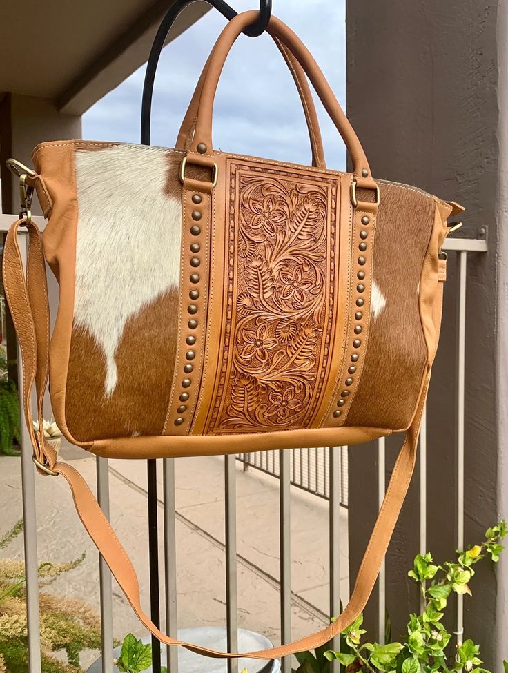 Gorgeous Tooled Leather tote or briefcase -  Texas sized The leather is very soft and luxurious. This tote is perfect to be used as a travel tote, diaper bag, work bag, big ole purse, weekender bag, crossbody purse... so many uses!! Main compartment holds your iPad, laptop, keys, wallet, phone, makeup bag, etc. Zippered closure Inside: - zippered pocket - 2 open pockets inside - leather handle, side and back - removable plain leather crossbody strap - these are one of a kind and cowhide will be different on every purse as no 2 are alike. 17" x 11.5" x 4" On-the-go Tote Briefcase With Detachable Handle, Brown Laptop Bag With Detachable Handle For Everyday, Travel Tote Briefcase, Brown Laptop Bag For Travel, Brown Laptop Bag With Detachable Handle For Travel, Leather Travel Bag With Top Carry Handle, Leather Travel Bag Tote With Top Carry Handle, Travel Laptop Bag With Detachable Handle In Brown, Leather Travel Tote Bag With Top Carry Handle