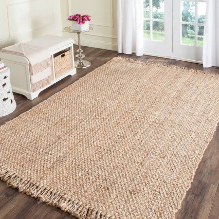 a large rug with fringes on the floor next to a white bench and window