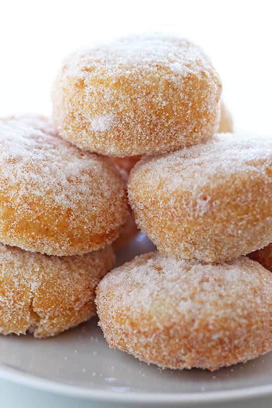 a pile of sugar covered doughnuts sitting on top of each other