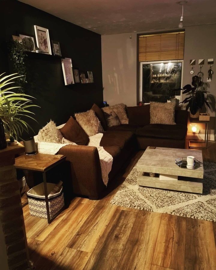 a living room filled with furniture and a coffee table on top of a hard wood floor