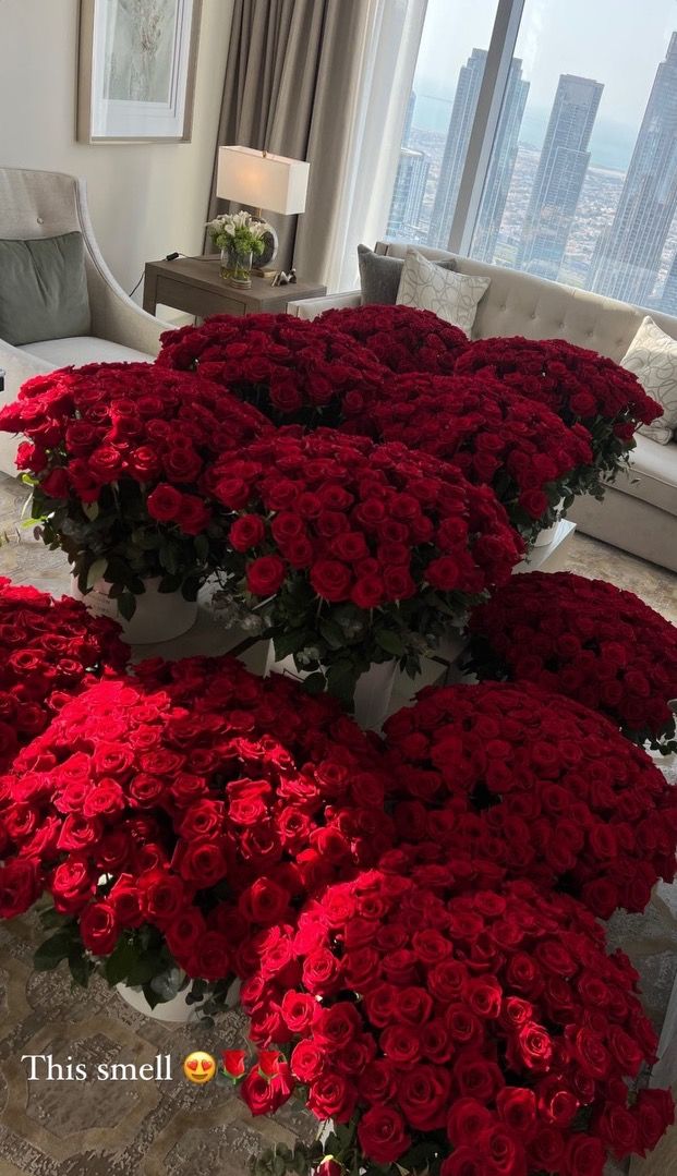 a living room filled with lots of red flowers