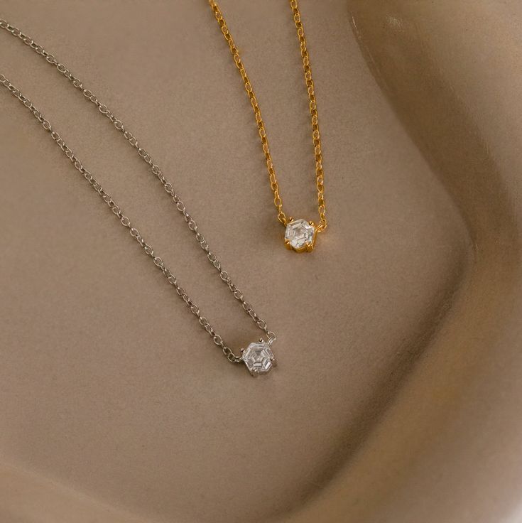 Explore modern elegance with our Hexagon Diamond Necklace, featuring a captivating rose-cut diamond at its core. This dainty and geometric piece effortlessly combines sophistication with contemporary charm, offering a unique allure for any occasion. Material: High Quality 925 Solid Sterling Silver Finish: 18K Gold ∙ Sterling Silver Featuring a ~4.5mm x 4mm Hexagonal Rose-Cut CZ Diamond Charm on a dainty Cable Chain, adjustable from 16 to 18 inches Part of our Diamond & Pavé Collection SKU: RR-NR Minimalist Rose Cut Diamond Necklaces For Anniversary, Minimalist Solitaire Necklace With Rose Cut Diamonds, Minimalist Solitaire Necklace With Rose Cut Diamonds As Gift, Elegant Everyday Solitaire Necklace With Delicate Chain, Elegant Diamond-shaped Necklace With Single Diamond, Elegant Diamond White Octagon Necklace, Timeless Necklace With Rose Cut Diamonds As Gift, Elegant Everyday Jewelry With Rose Cut Diamonds, Timeless Necklace With Rose Cut Diamonds For Gift