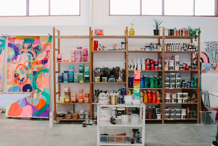 a room filled with lots of different types of paint and art supplies on shelving