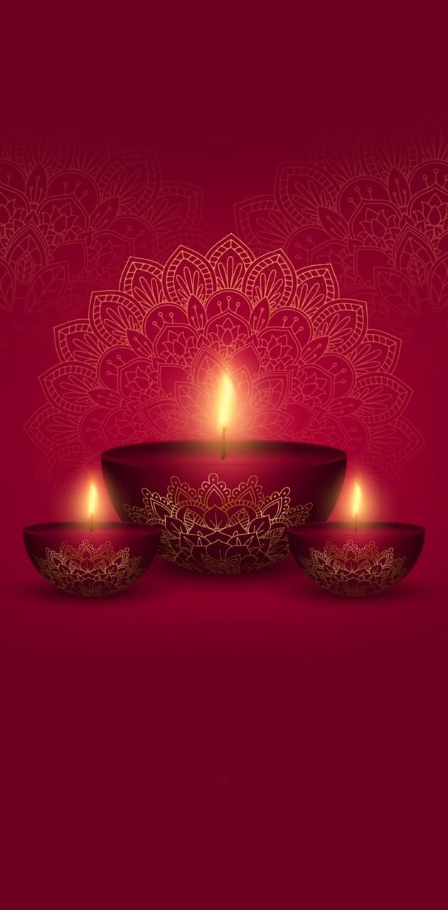 three lit candles in front of a red background with an intricate design on the wall